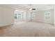 Spacious carpeted bedroom with tray ceiling, ceiling fan, and ample natural light, perfect for relaxation at 2445 Whitehead Place Dr, Suwanee, GA 30024