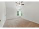 Bright bedroom featuring neutral carpet, white walls, ceiling fan, and natural light from the windows at 2445 Whitehead Place Dr, Suwanee, GA 30024