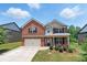 Charming two-story brick home with attached garage, manicured lawn, and mature landscaping at 2445 Whitehead Place Dr, Suwanee, GA 30024