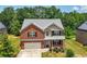 Charming two-story brick home with attached garage, well-manicured lawn, and mature landscaping at 2445 Whitehead Place Dr, Suwanee, GA 30024