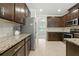 Elegant kitchen showcases granite countertops, dark wood cabinets, and stainless-steel appliances at 2445 Whitehead Place Dr, Suwanee, GA 30024
