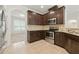 Close-up of the kitchen featuring dark wood cabinetry, stainless steel appliances, and tile backsplash at 2445 Whitehead Place Dr, Suwanee, GA 30024