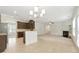 Open-concept living space with fireplace flows into spacious kitchen featuring dark wood cabinets and granite countertops at 2445 Whitehead Place Dr, Suwanee, GA 30024