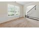 Living room featuring wainscoting, a large window, and an open staircase to the upper level at 2445 Whitehead Place Dr, Suwanee, GA 30024