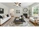 Inviting living room with fireplace, ceiling fan, modern decor, and large windows for natural light at 2445 Whitehead Place Dr, Suwanee, GA 30024