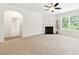 Spacious living room featuring a fireplace, neutral carpeting, and a doorway to an en-suite bathroom at 2445 Whitehead Place Dr, Suwanee, GA 30024