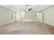 A carpeted primary bedroom featuring a tray ceiling and ceiling fan, with neutral tones for versatile decor at 2445 Whitehead Place Dr, Suwanee, GA 30024