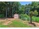 Outdoor storage shed situated on a lush green lot surrounded by mature trees at 2445 Whitehead Place Dr, Suwanee, GA 30024