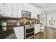 Close up of stainless steel oven and range with dark countertops and white cabinets in kitchen at 434 Westlake Nw Dr, Marietta, GA 30064