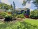 Back exterior featuring blue siding, mature trees, established landscaping, and a walkout basement at 5130 Dearing St, Covington, GA 30014