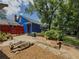 Cozy backyard featuring a patio, fire pit, blue siding, mature trees, and lush greenery at 5130 Dearing St, Covington, GA 30014