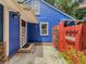 Charming home exterior with a red gate, white door trim, blue siding, and well maintained landscaping at 5130 Dearing St, Covington, GA 30014