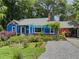 Charming home exterior with a blue paint, covered patio, mature landscaping, and a gravel driveway at 5130 Dearing St, Covington, GA 30014