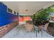 Covered patio with blue wood siding, brick base, concrete floor, wicker furniture set, and overhead lighting at 5130 Dearing St, Covington, GA 30014