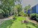 Expansive backyard featuring lush grass, established landscaping, blue siding, and mature trees at 5130 Dearing St, Covington, GA 30014
