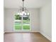 Bright dining area featuring hardwood floors, a modern chandelier, and a large window overlooking the lawn at 600 Applewood Nw Ln, Marietta, GA 30064
