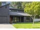 Modern dark wood home with attached garage, lush green lawn, and stylish front windows at 600 Applewood Nw Ln, Marietta, GA 30064