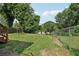 Well-maintained backyard with green grass, mature trees, and a wooden deck, creating a relaxing outdoor space at 524 Paines Nw Ave, Atlanta, GA 30318