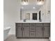 A modern bathroom features a double sink vanity, bathtub and mirror with attractive fixtures at 1128 E Shoreview Rd, Mcdonough, GA 30253