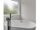 A stylish freestanding tub with a view to the outside offers relaxation and privacy at 1128 E Shoreview Rd, Mcdonough, GA 30253