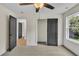 Neutral bedroom featuring a ceiling fan, plush carpet, closet, and a large window with natural light at 1128 E Shoreview Rd, Mcdonough, GA 30253