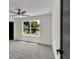 Neutral bedroom featuring a ceiling fan, plush carpet, and a large window with natural light at 1128 E Shoreview Rd, Mcdonough, GA 30253