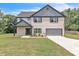 Charming two-story home featuring a painted brick exterior, inviting front porch, and attached two-car garage at 1128 E Shoreview Rd, Mcdonough, GA 30253