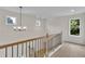 Second-floor hallway featuring light wood floors, modern lighting, and bright windows at 1128 E Shoreview Rd, Mcdonough, GA 30253