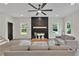 Bright living room with fireplace, white sofas, and large windows overlooking backyard at 1128 E Shoreview Rd, Mcdonough, GA 30253