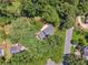 Aerial view of property surrounded by lush greenery and trees at 3835 Thornhill Sw Dr, Lilburn, GA 30047