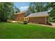 A well-maintained backyard with a new wooden deck adjacent to a brick house on a bright, sunny day at 3835 Thornhill Sw Dr, Lilburn, GA 30047