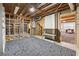 Partially finished basement featuring framed walls, exposed ceiling, and a mix of concrete and carpet flooring at 3835 Thornhill Sw Dr, Lilburn, GA 30047