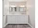Bathroom featuring double sink vanity with marble countertop and silver framed mirrors at 3835 Thornhill Sw Dr, Lilburn, GA 30047