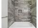 Stylish bathroom showcasing gray tiled shower walls and a modern white tub at 3835 Thornhill Sw Dr, Lilburn, GA 30047