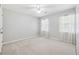 This cozy bedroom features neutral carpeting, a ceiling fan, and bright natural light from two windows at 3835 Thornhill Sw Dr, Lilburn, GA 30047