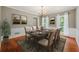 Traditional dining room with hardwood floors, chandelier, wainscoting, neutral walls and set table for six at 3835 Thornhill Sw Dr, Lilburn, GA 30047