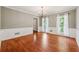 Dining room featuring hardwood flooring, decorative chandelier, wainscoting, neutral walls, and bright, natural light at 3835 Thornhill Sw Dr, Lilburn, GA 30047