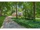 Long driveway leading up to a two-story home with an attached garage, surrounded by lush greenery at 3835 Thornhill Sw Dr, Lilburn, GA 30047