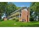 Two-story brick home featuring a welcoming front porch, gable roof, and lush green lawn at 3835 Thornhill Sw Dr, Lilburn, GA 30047