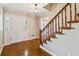 Welcoming foyer featuring wood floors, a staircase, and a front door with sidelights for an inviting entrance at 3835 Thornhill Sw Dr, Lilburn, GA 30047