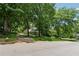 Charming house with a brick garage, surrounded by lush green trees on a sunny day at 3835 Thornhill Sw Dr, Lilburn, GA 30047
