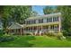 Charming two-story brick home featuring a welcoming front porch and well-manicured lawn surrounded by mature trees at 3835 Thornhill Sw Dr, Lilburn, GA 30047