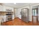 Bright kitchen with stainless steel appliances, white cabinets, granite countertops, and hardwood flooring at 3835 Thornhill Sw Dr, Lilburn, GA 30047