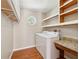 Bright laundry room featuring hardwood floors, window, storage shelves, and modern washer and dryer at 3835 Thornhill Sw Dr, Lilburn, GA 30047