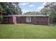 Brick home back exterior featuring a shed and large manicured lawn at 4051 Dixie Ln, Douglasville, GA 30135