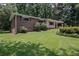 Charming brick home with a well-maintained lawn and mature trees at 4051 Dixie Ln, Douglasville, GA 30135