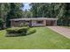 Well-maintained home with a green lawn, mature landscaping, and a carport at 4051 Dixie Ln, Douglasville, GA 30135