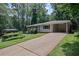 Charming single-story home with a long driveway and carport nestled among mature trees at 4051 Dixie Ln, Douglasville, GA 30135