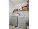 Functional laundry room with washer, dryer, and shelving at 4051 Dixie Ln, Douglasville, GA 30135