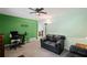 Cozy living room with a green accent wall, ceiling fan and black leather seating at 4051 Dixie Ln, Douglasville, GA 30135
